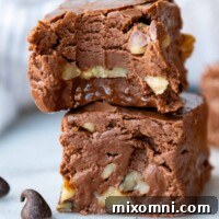 a stack of 2 pieces of fudge with the top one having a bite out.