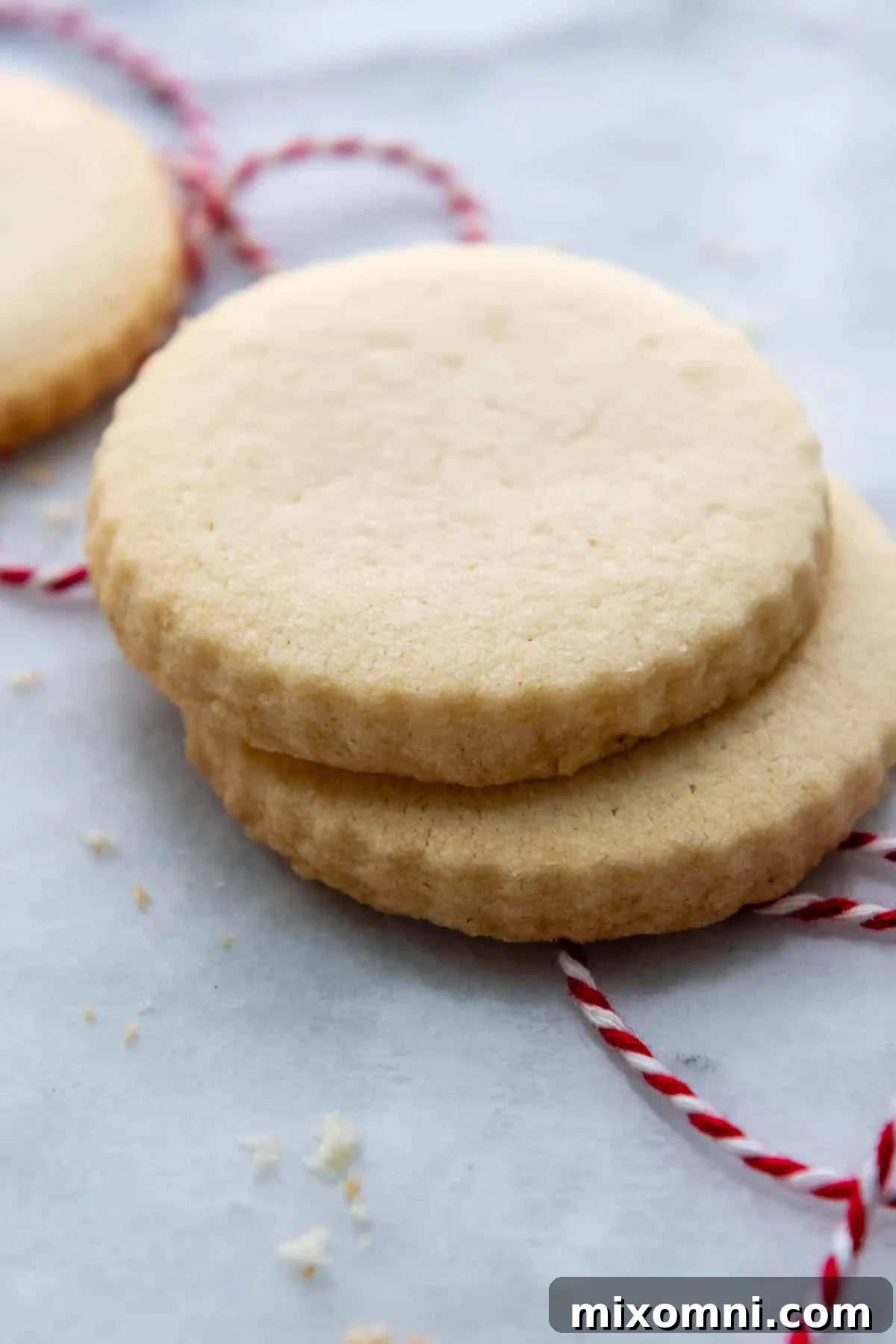 Two perfectly stacked gluten-free shortbread cookies on an elegant marble surface, showcasing their golden edges and delicate crumb.