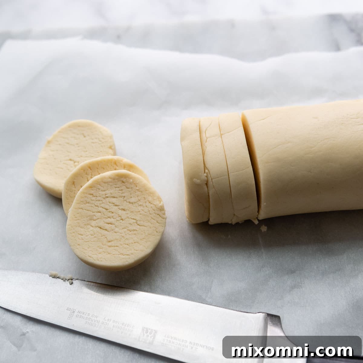 A neatly sliced log of gluten-free shortbread cookie dough, showing uniform rounds ready for baking.