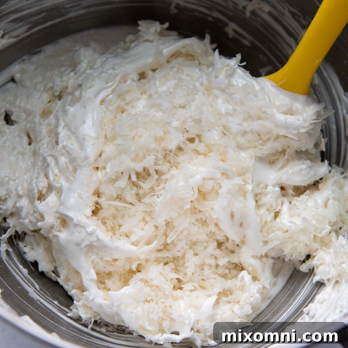 coconut being stirred into egg whites.