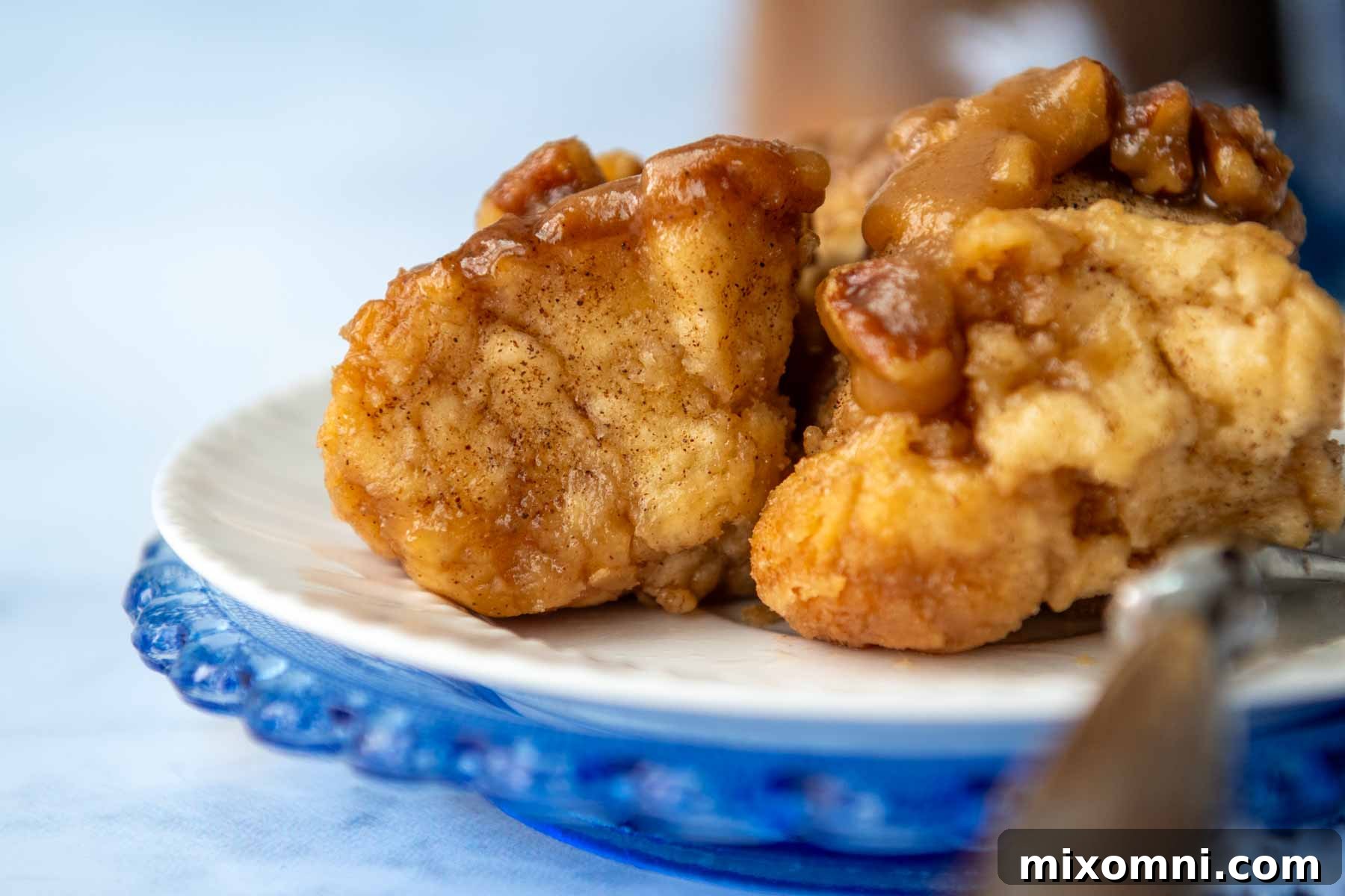 A single serving of warm gluten-free monkey bread on a white plate with a fork, showing its pull-apart texture.