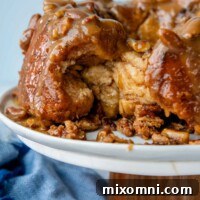 Gluten-free monkey bread on a cake platter with some of it pulled out.
