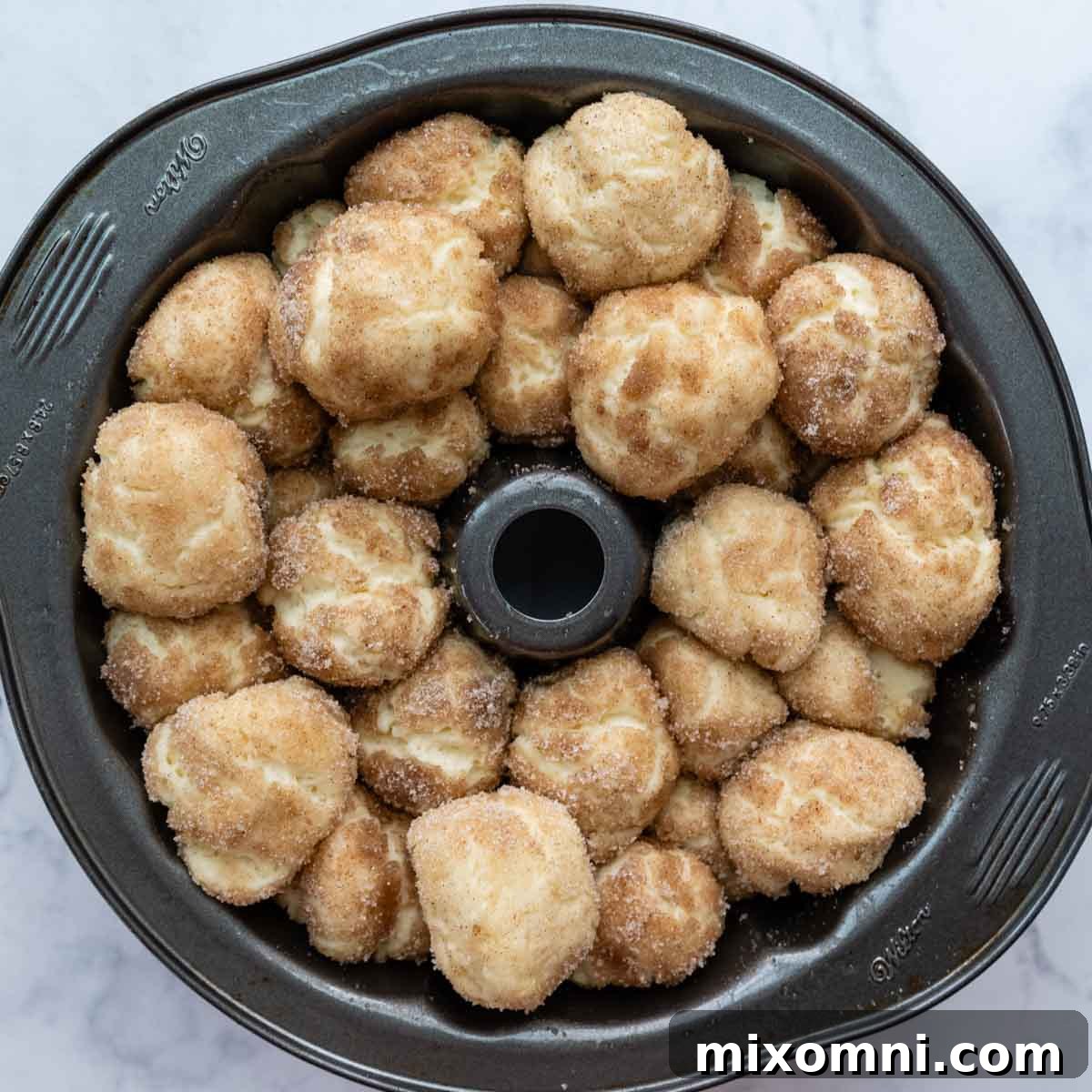 The dough balls in the bundt pan after rising, showing noticeable expansion, before baking.