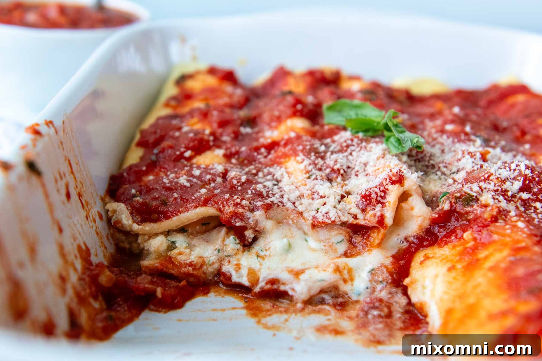 A baking dish filled with golden-brown baked gluten-free manicotti, with a few servings already removed, highlighting its appeal.