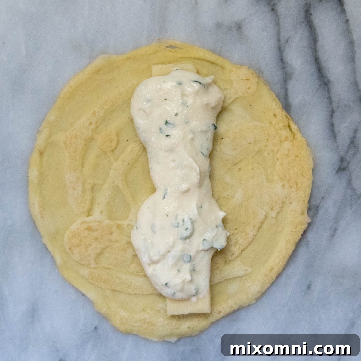 Creamy ricotta filling generously spooned over the mozzarella strip on a gluten-free crepe.