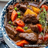overhead shot of a bowl of beef stew with a blue napkin.