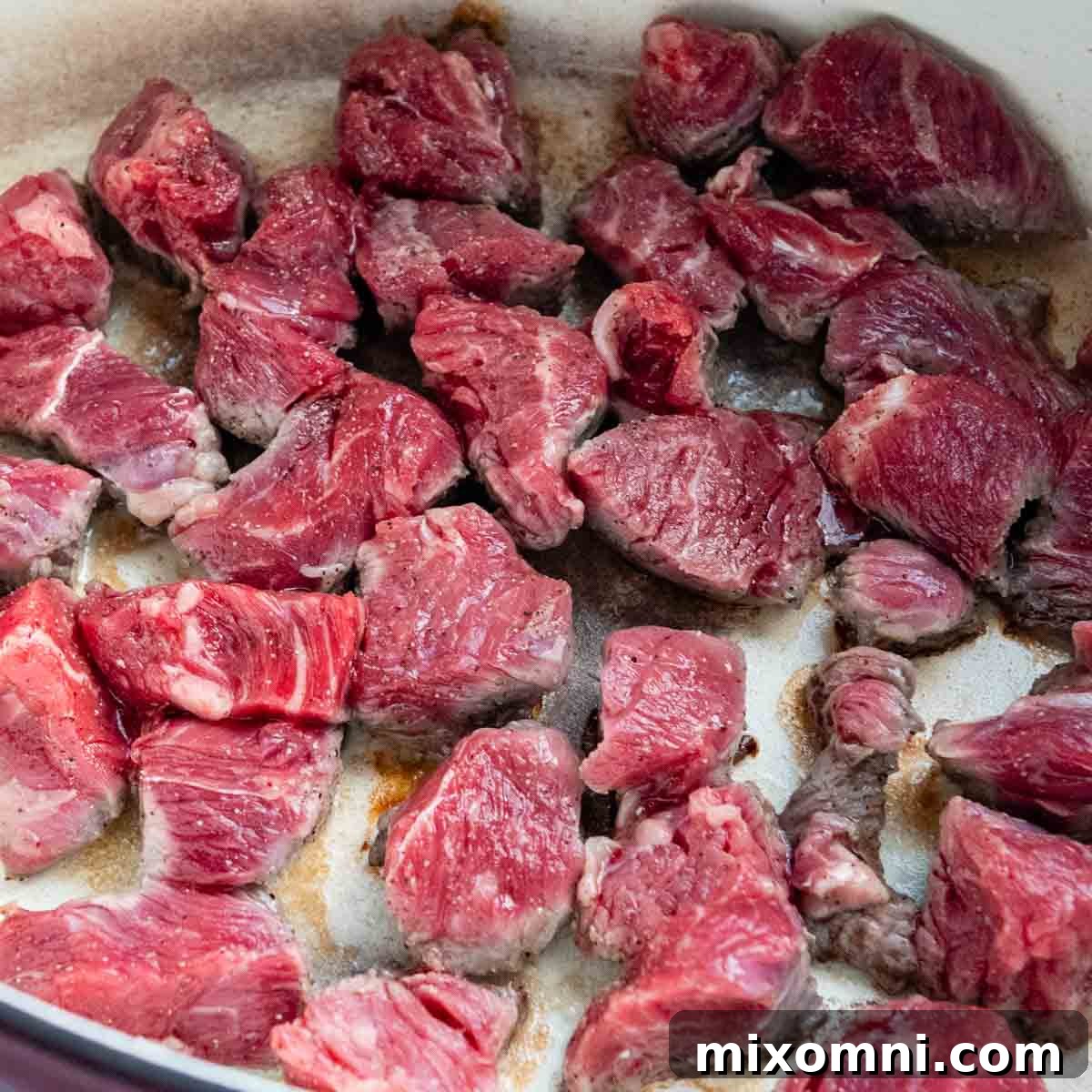 meat being seared in a dutch oven.