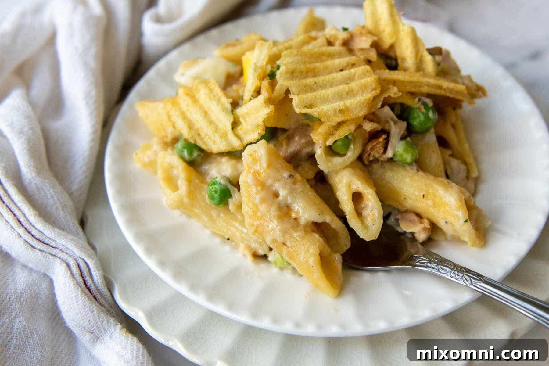 close up of casserole serving on a white plate with a fork going into it