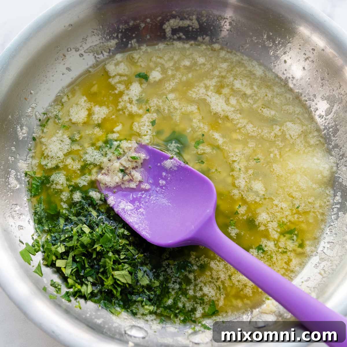 Melted butter in a skillet, gently cooking minced garlic and fresh parsley until fragrant.