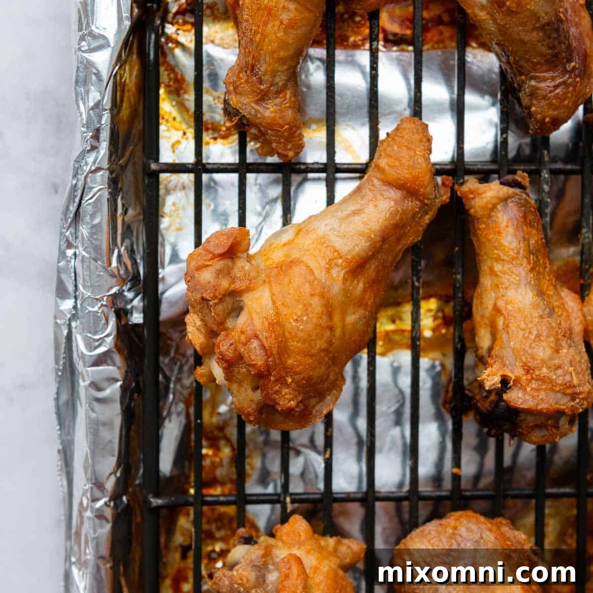 A close-up of a perfectly baked, golden-brown chicken wing with crispy skin.