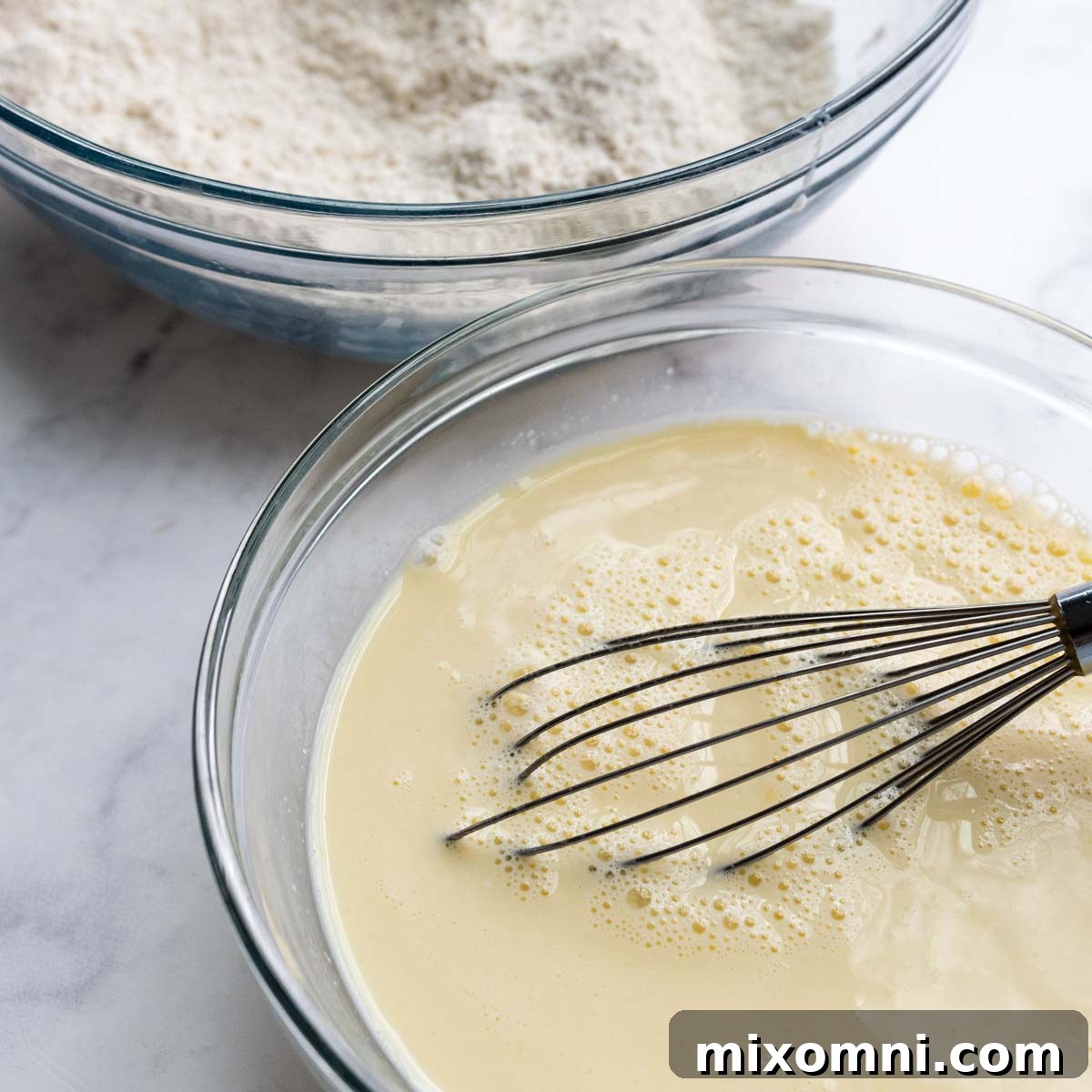 Wet ingredients whisked in one bowl and dry ingredients in another, ready to be combined for gluten-free pancake batter.