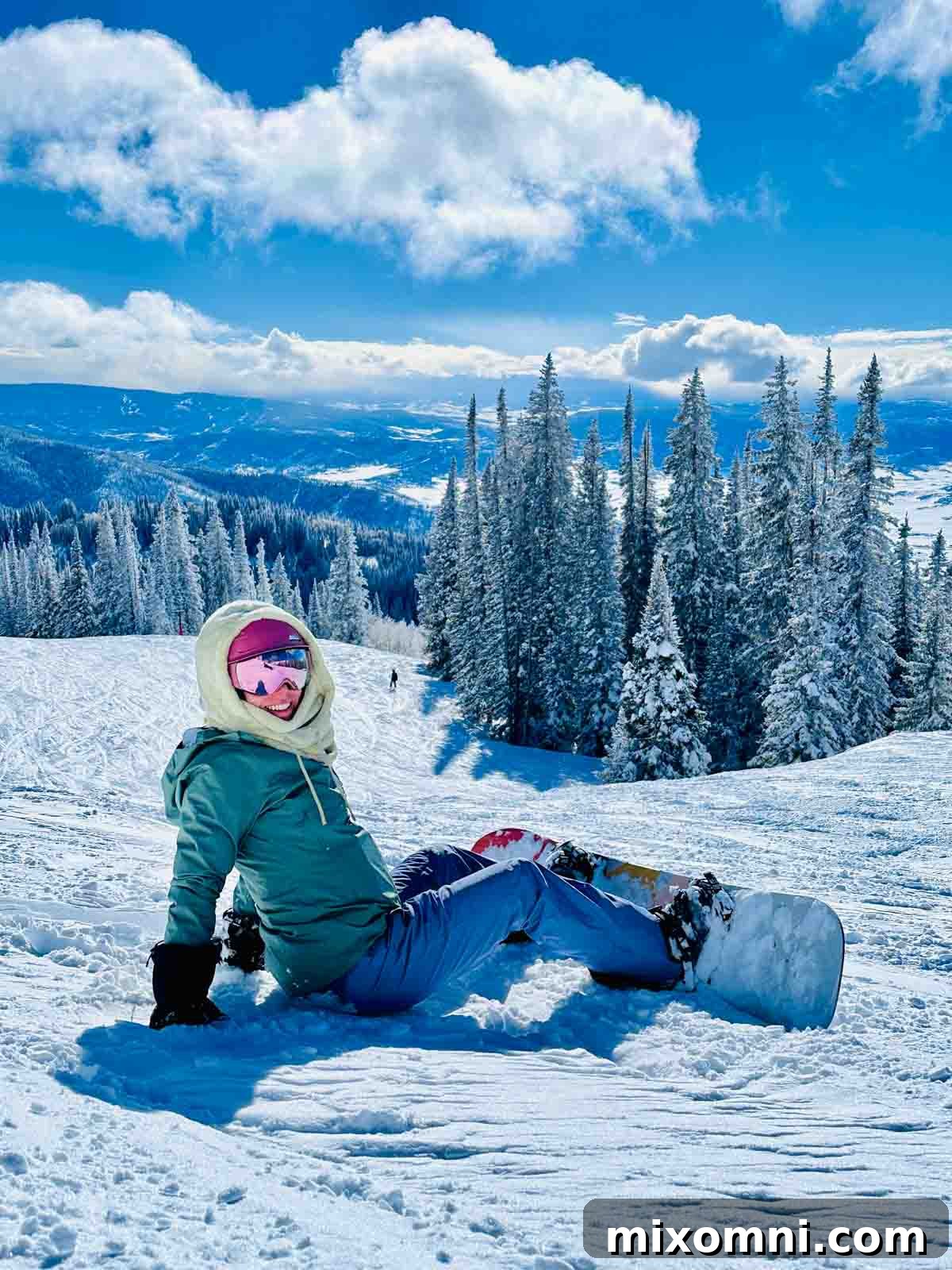 Melissa Erdelac enjoying snowboarding on fresh powder in Steamboat Springs, with a backdrop of snow-covered trees.