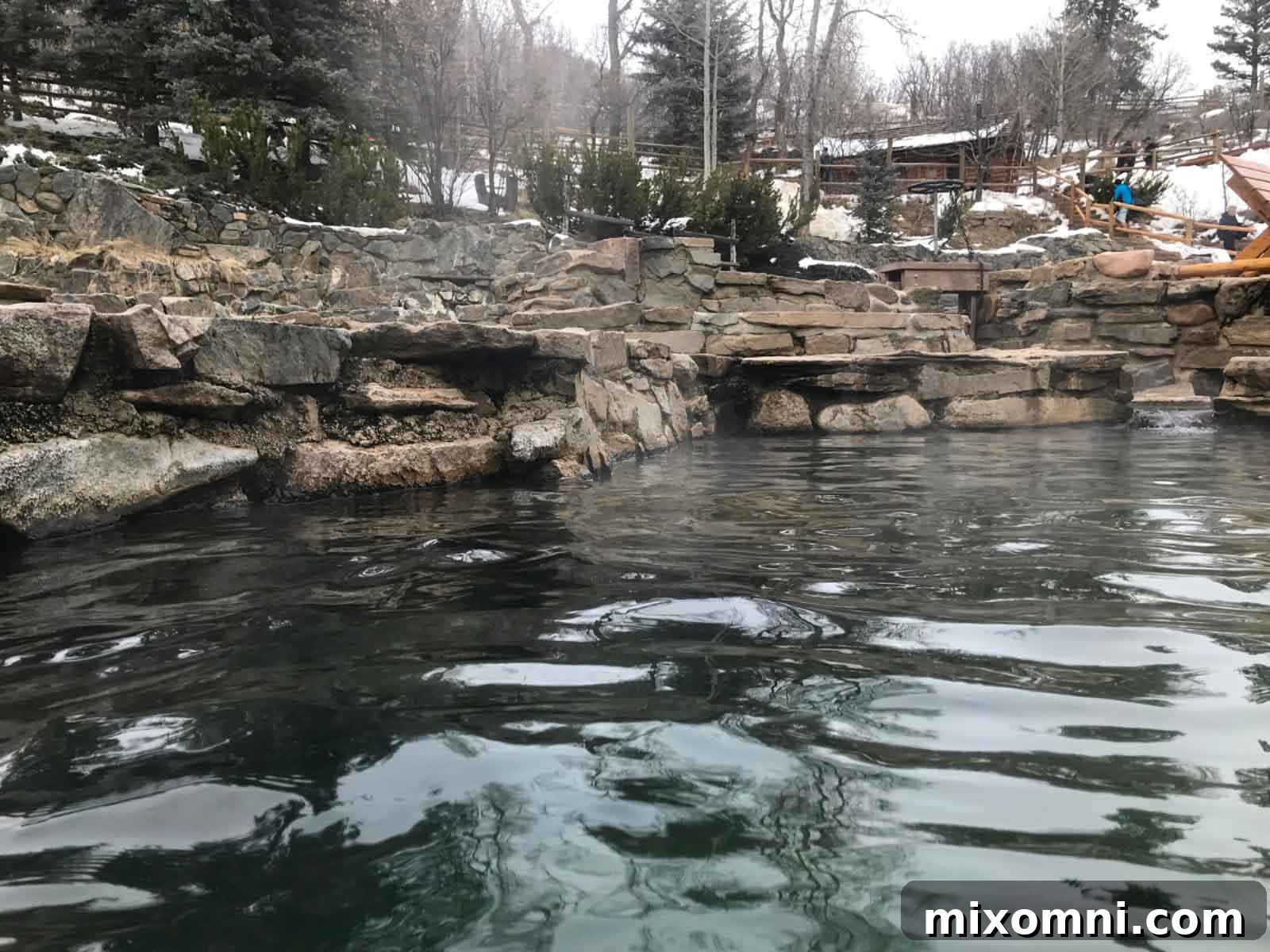 The natural mineral pools of Strawberry Park Hot Springs, nestled in a snow-covered forest, inviting visitors to relax.