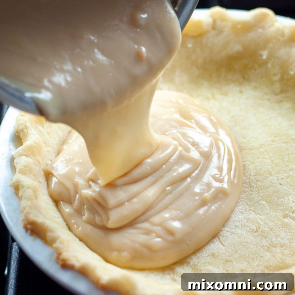 the custard being poured into the partially baked crust.