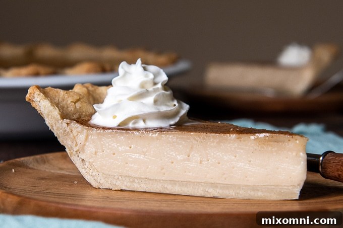 side angle close up of a piece of pie on a wooden plate with whipped cream on top