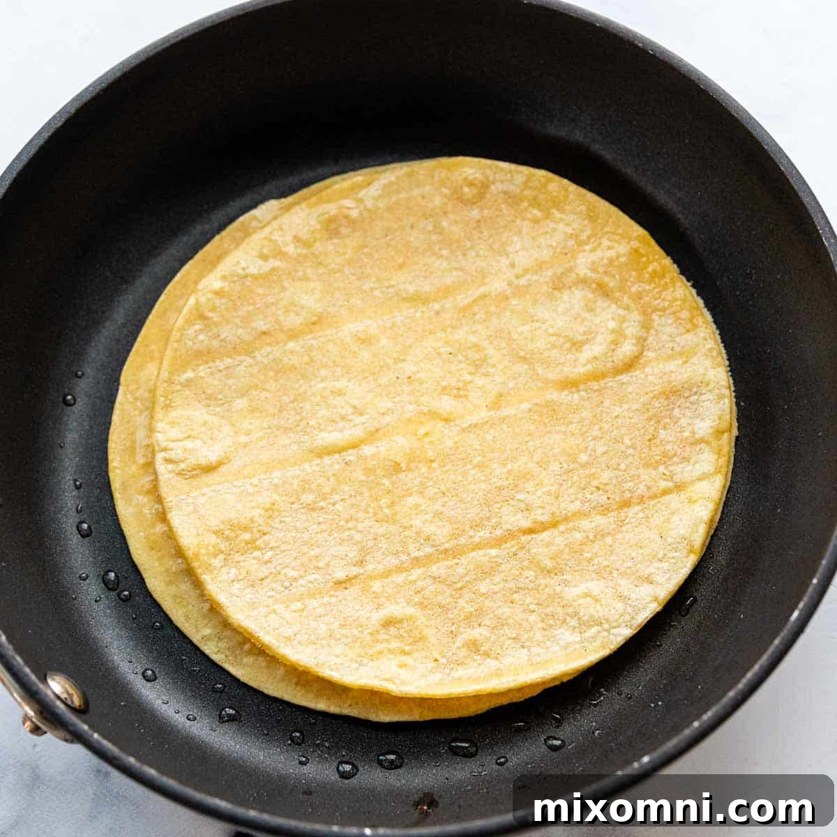 3 corn tortillas in a skillet.