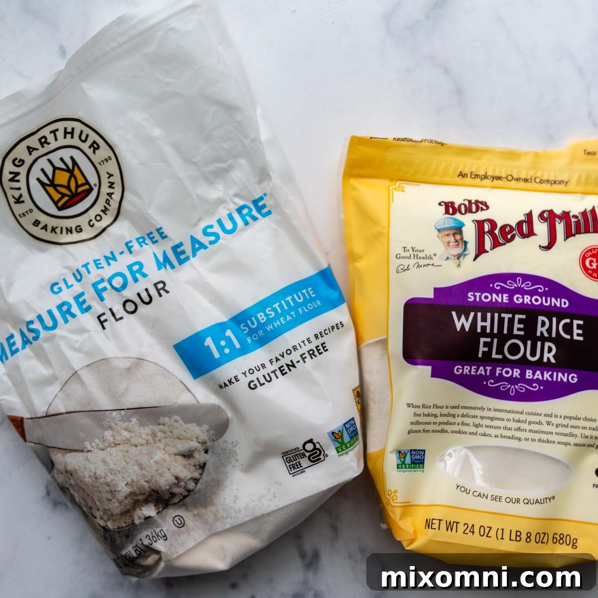 Two key ingredients for the gluten-free fish batter: a bag of King Arthur Measure-for-Measure gluten-free flour and a bag of white rice flour, displayed on a sleek marble surface.