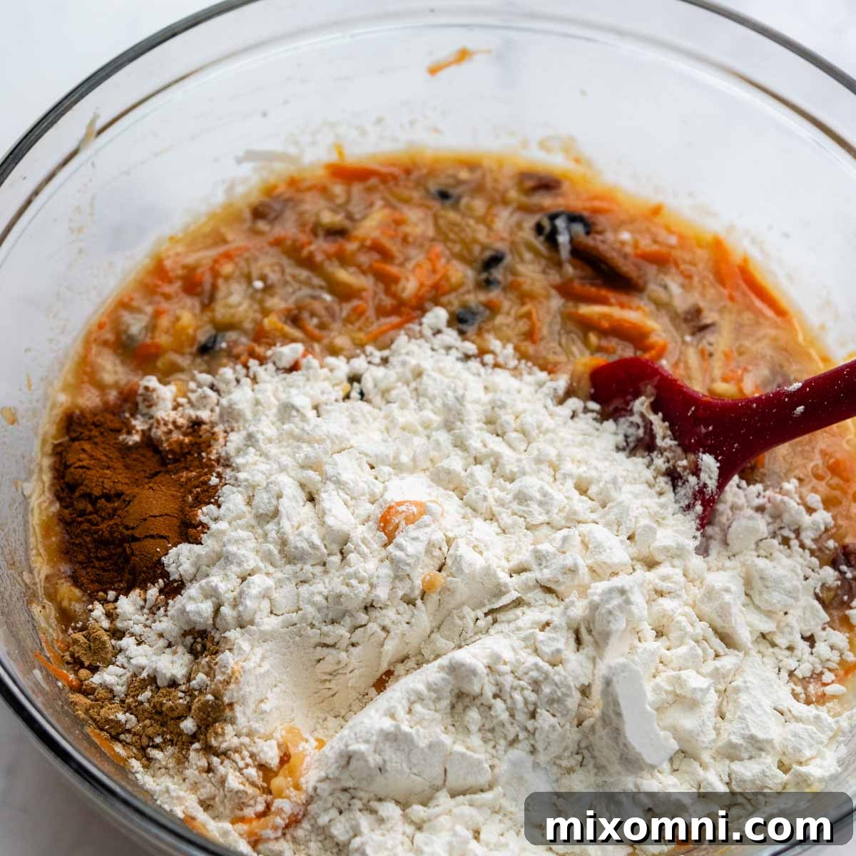 the dry ingredients being mixed into the bowl with the wet ingredients and mix-ins.