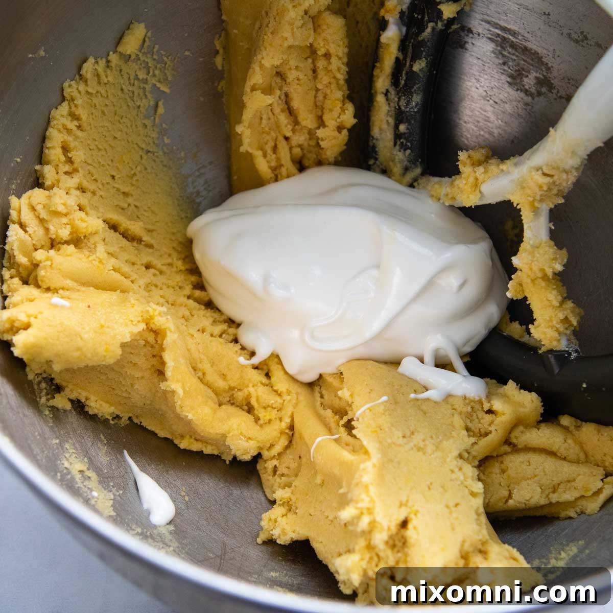 egg whites with a thicker cake batter in bowl.