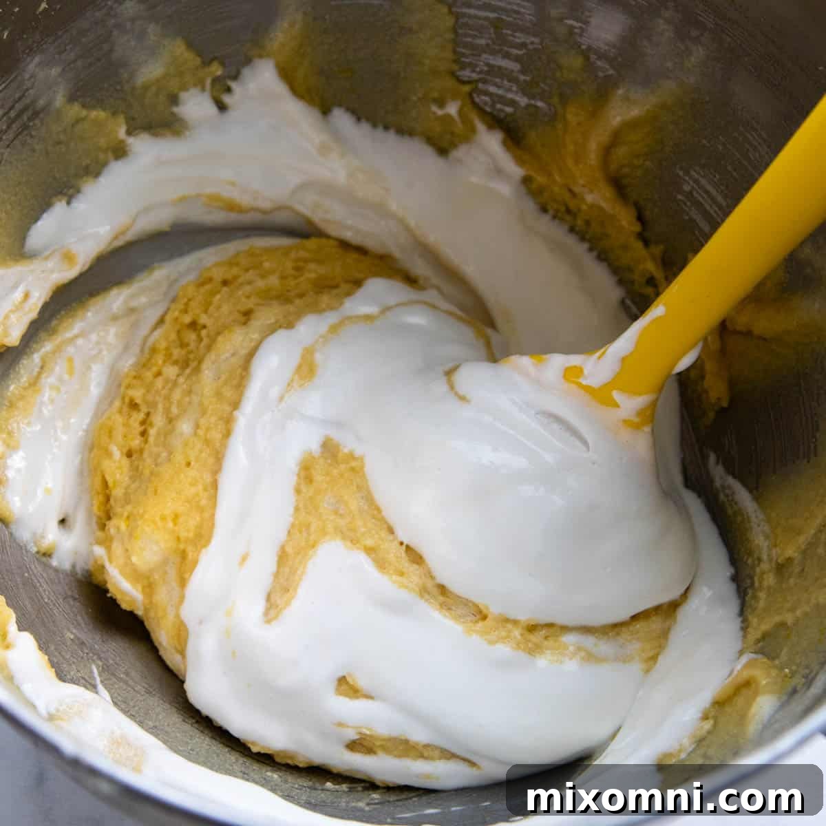 egg whites being folded into almond flour mixture.