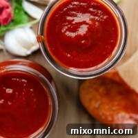 top view to 2 glass jars with sauce and a wooden spoon next to it.