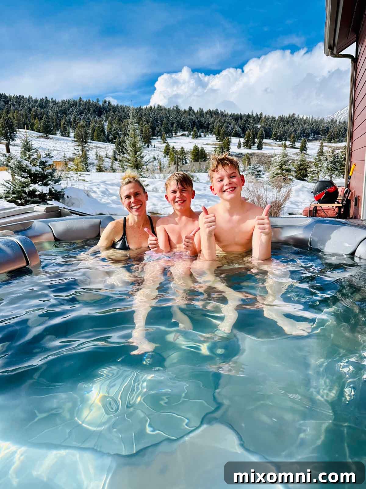 Melissa Erdelac with kids enjoying a private hot tub with a mountain view.