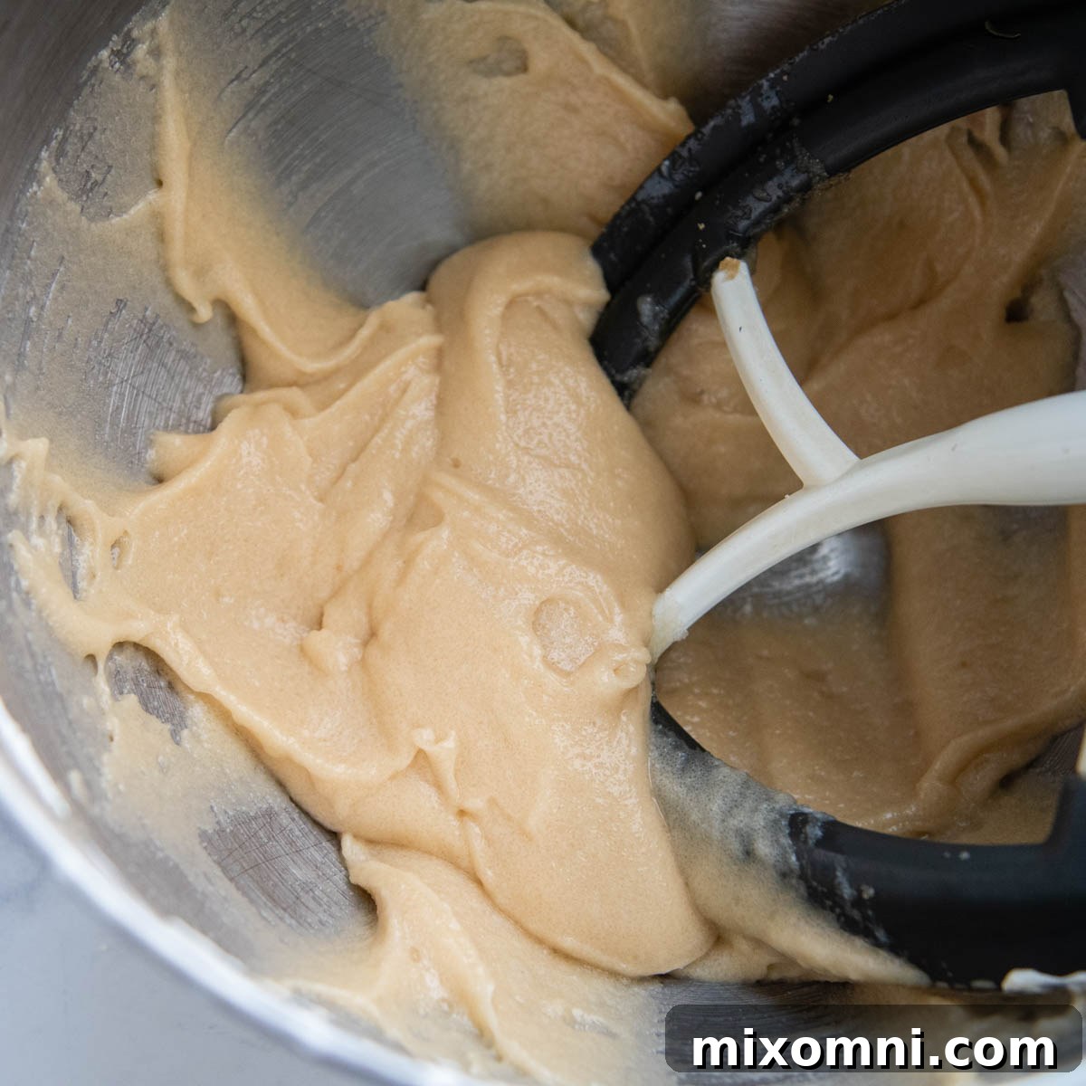 The initial banana cake batter after mixing sugars with butter, oil, and sour cream until light and creamy.