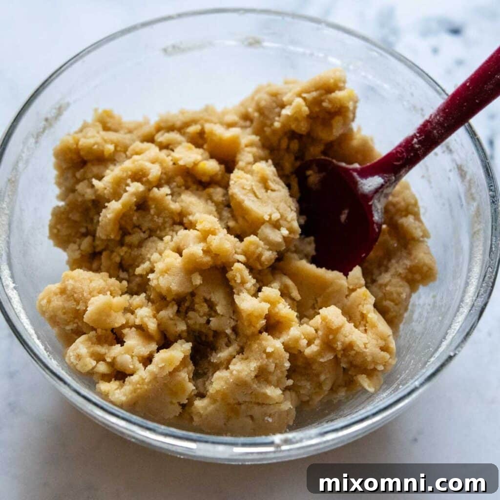 Gluten-free crumb topping mixture in a mixing bowl, ready to be sprinkled.