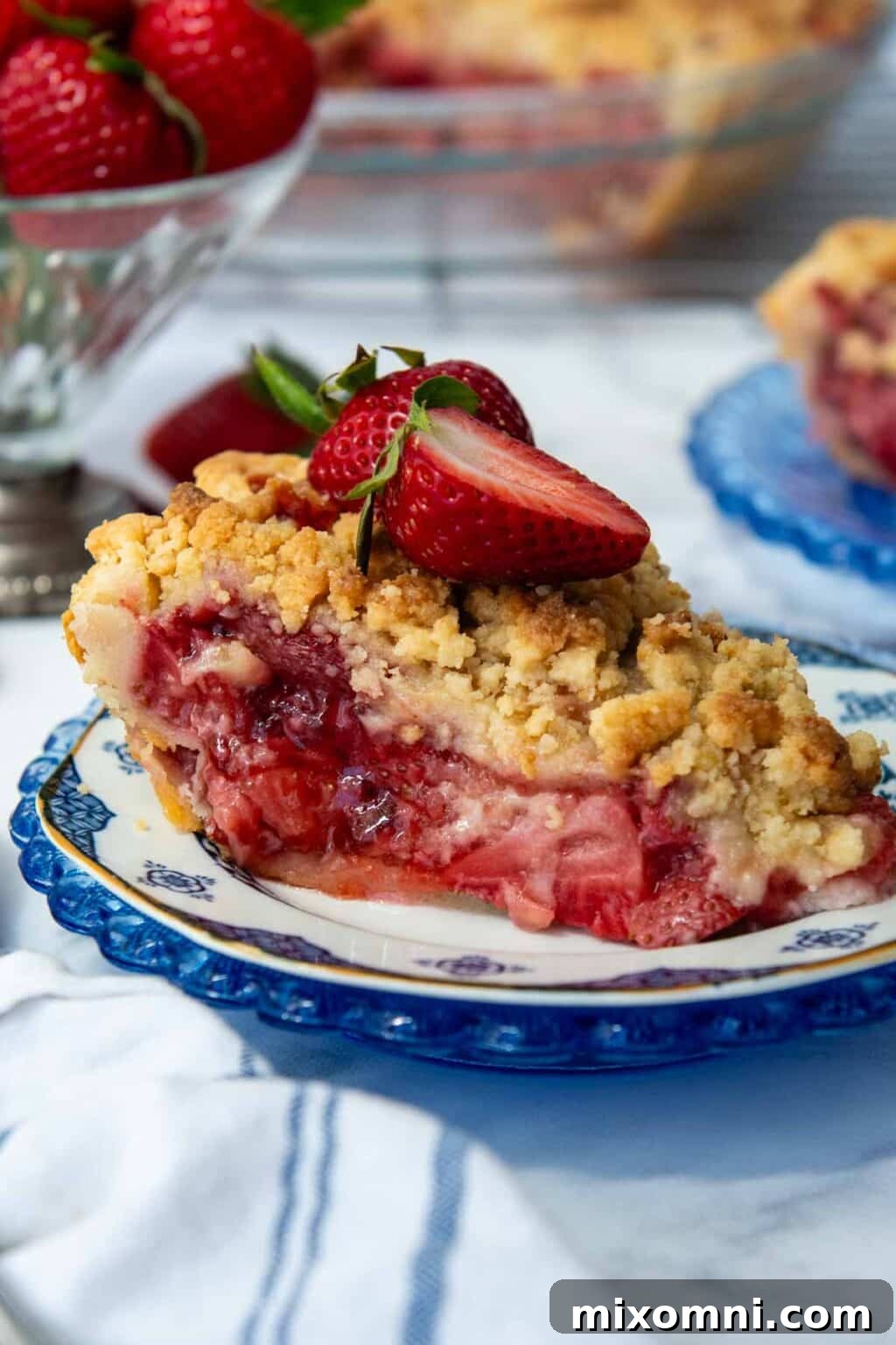 A beautifully presented slice of gluten-free strawberry pie topped with fresh whole strawberries.