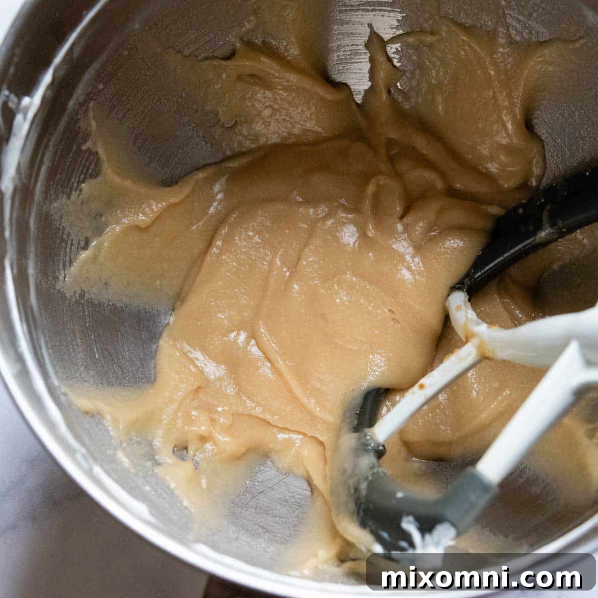 The butter, oil, sour cream, and sugars blended together in a mixing bowl, creating a smooth, creamy base.