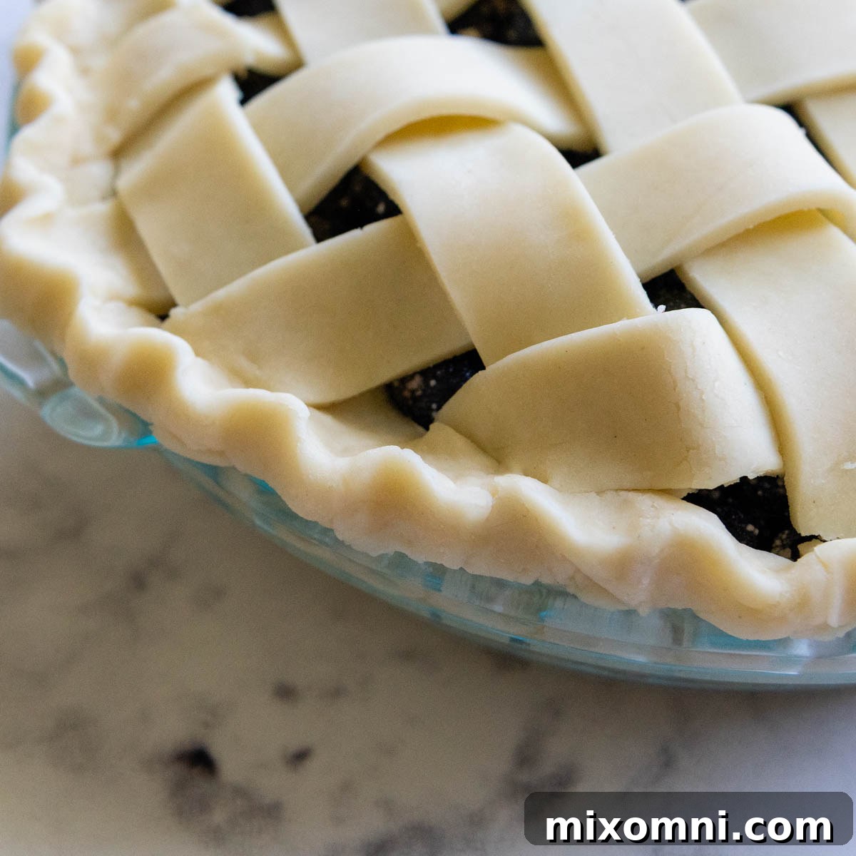 The beautifully fluted edge of the pie crust after shaping, demonstrating a decorative finish.