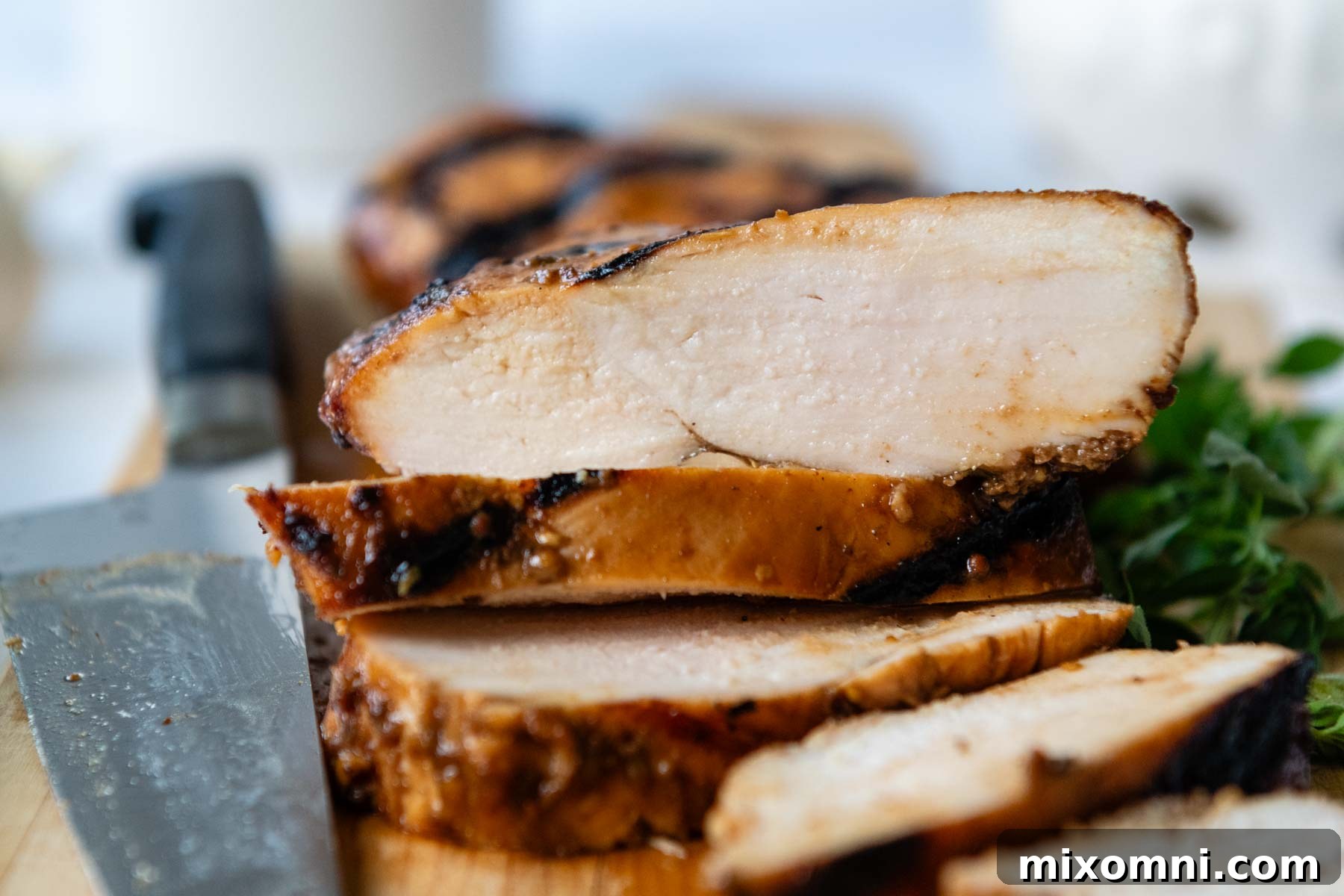a sliced chicken breast with a knife laying next to it.