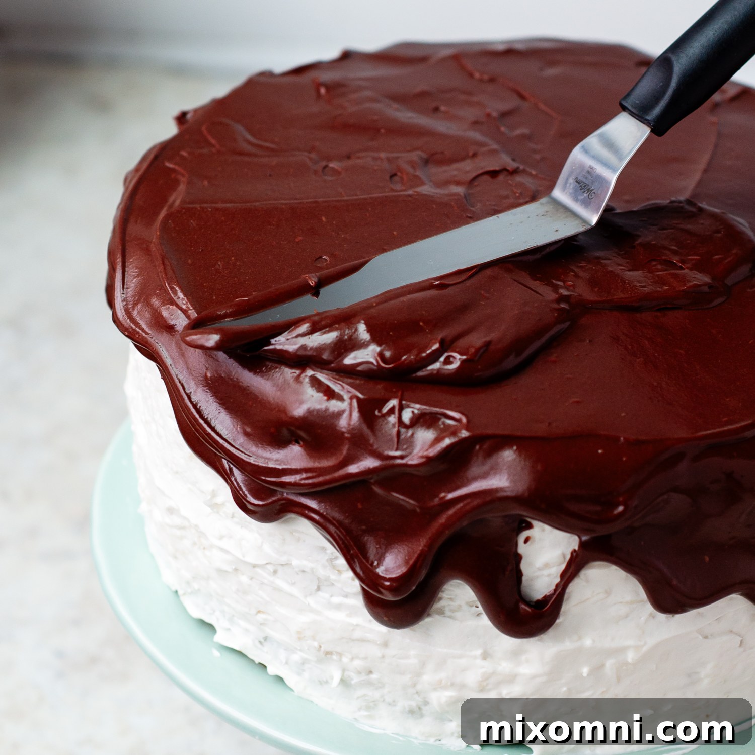Glossy chocolate frosting beautifully spread over the top of the cake, with alluring drips down the sides.