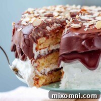 A beautifully cut piece of Almond Joy Cake being removed from the main cake, ready to be served.