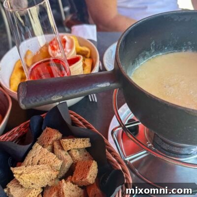 A warm, bubbling pot of Swiss cheese fondue served with perfectly toasted gluten-free bread cubes, inviting a safe and traditional dining experience for celiacs.