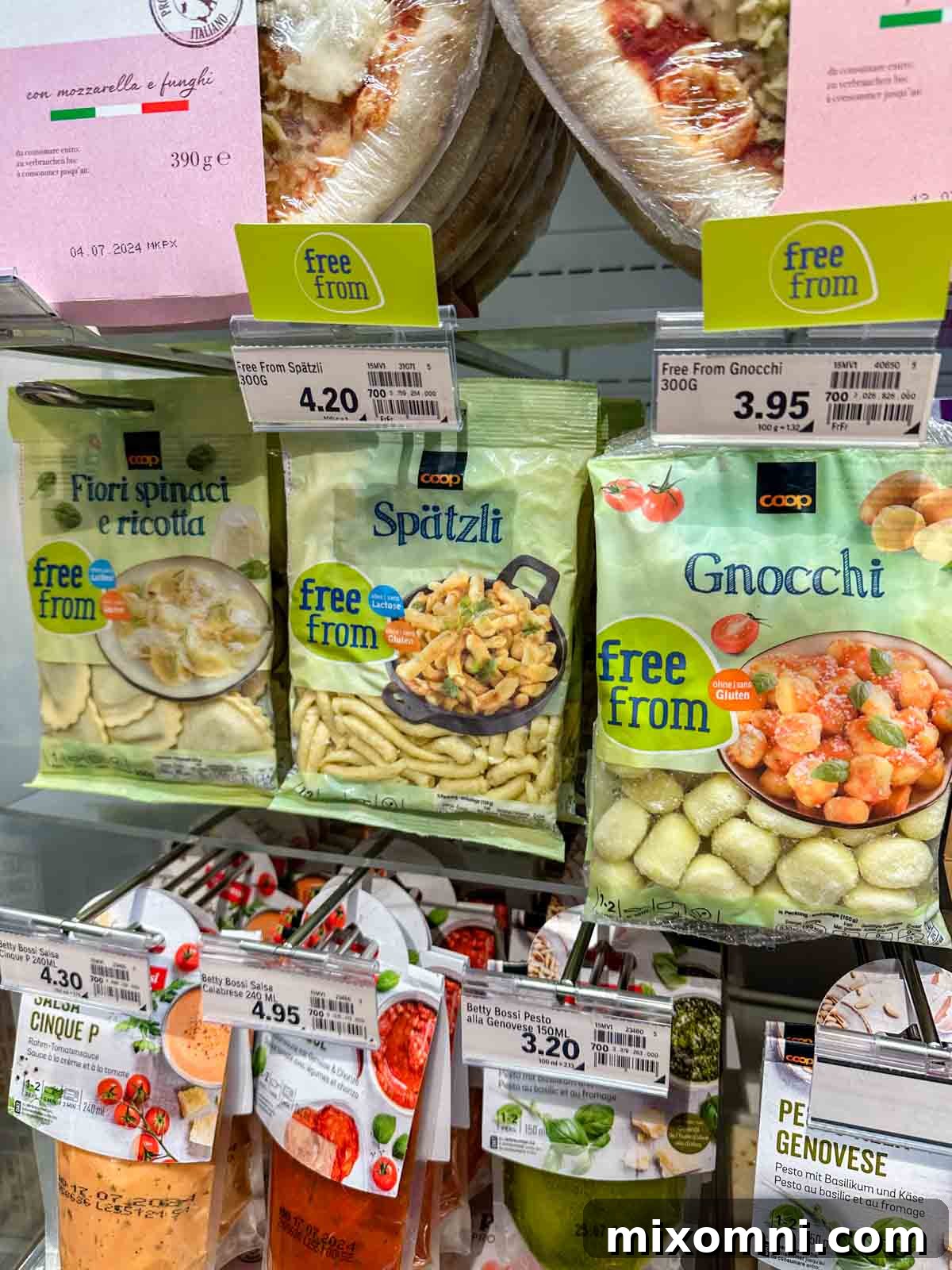 A grocery store shelf in Switzerland brimming with various types of gluten-free pasta, showcasing the wide availability of celiac-friendly options.