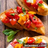 Three bruschetta slices on a wooden cutting board with fresh basil leaves.