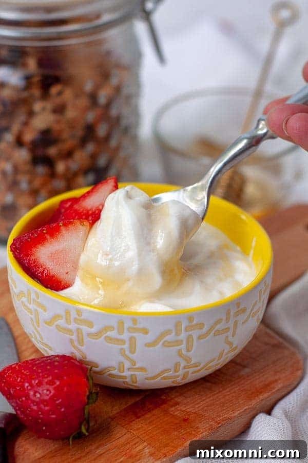 A spoon descending into a generous bowl of homemade Instant Pot yogurt, adorned with a luscious drizzle of golden honey.
