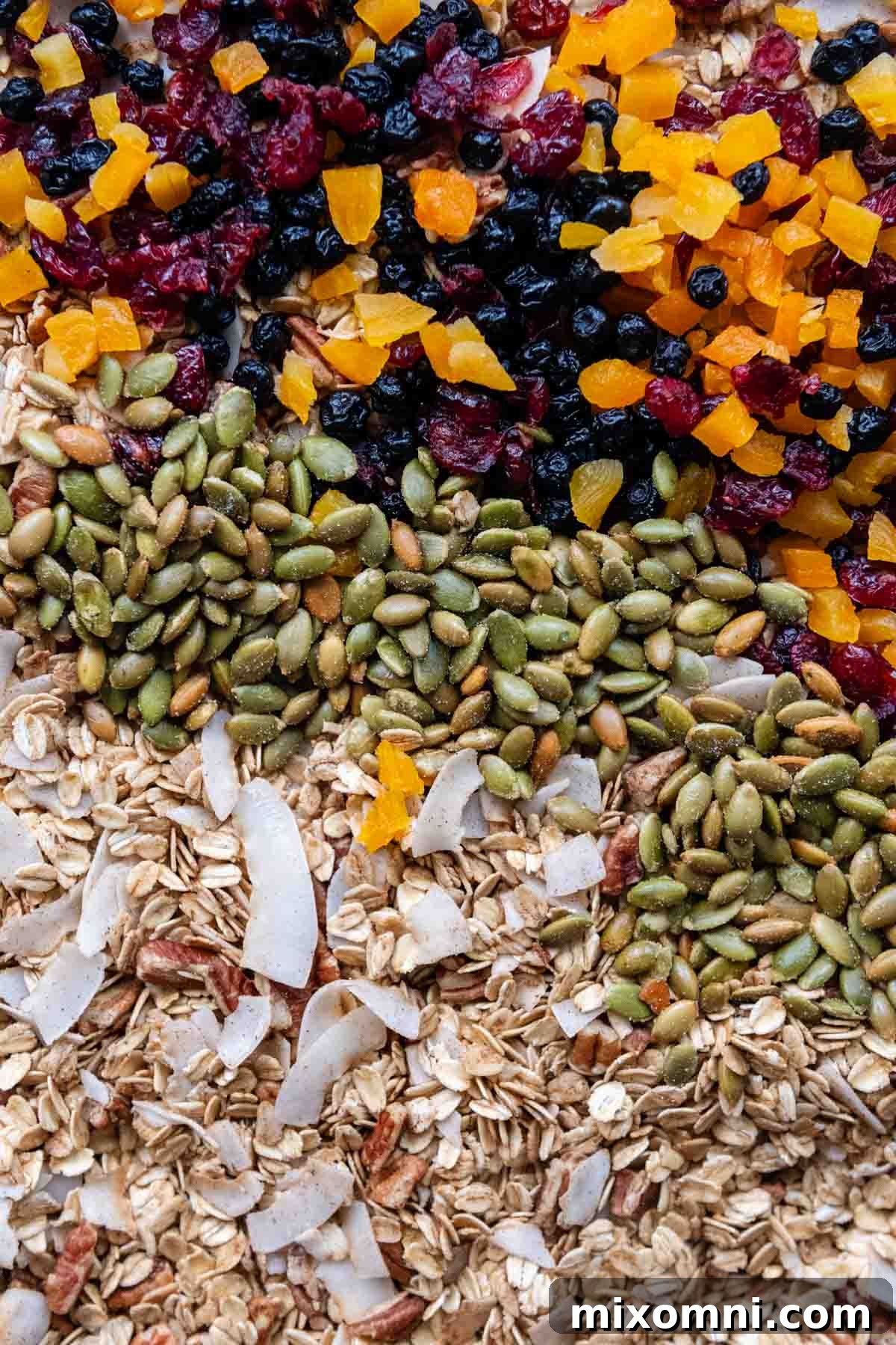 a sheet pan of muesli with the oats, pepitas, and dried fruits layered.