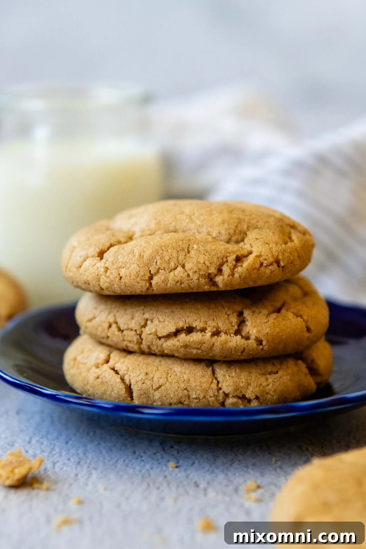 stack of 3 peanut butter cookies on a blue plate.