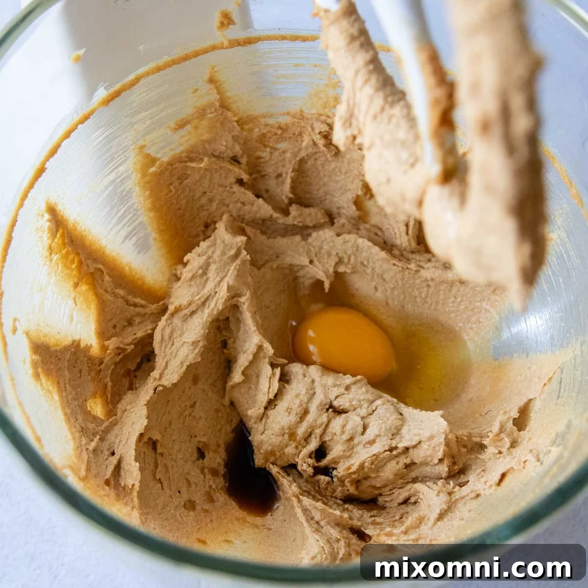 cookie dough in a glass bowl with an egg in the center.