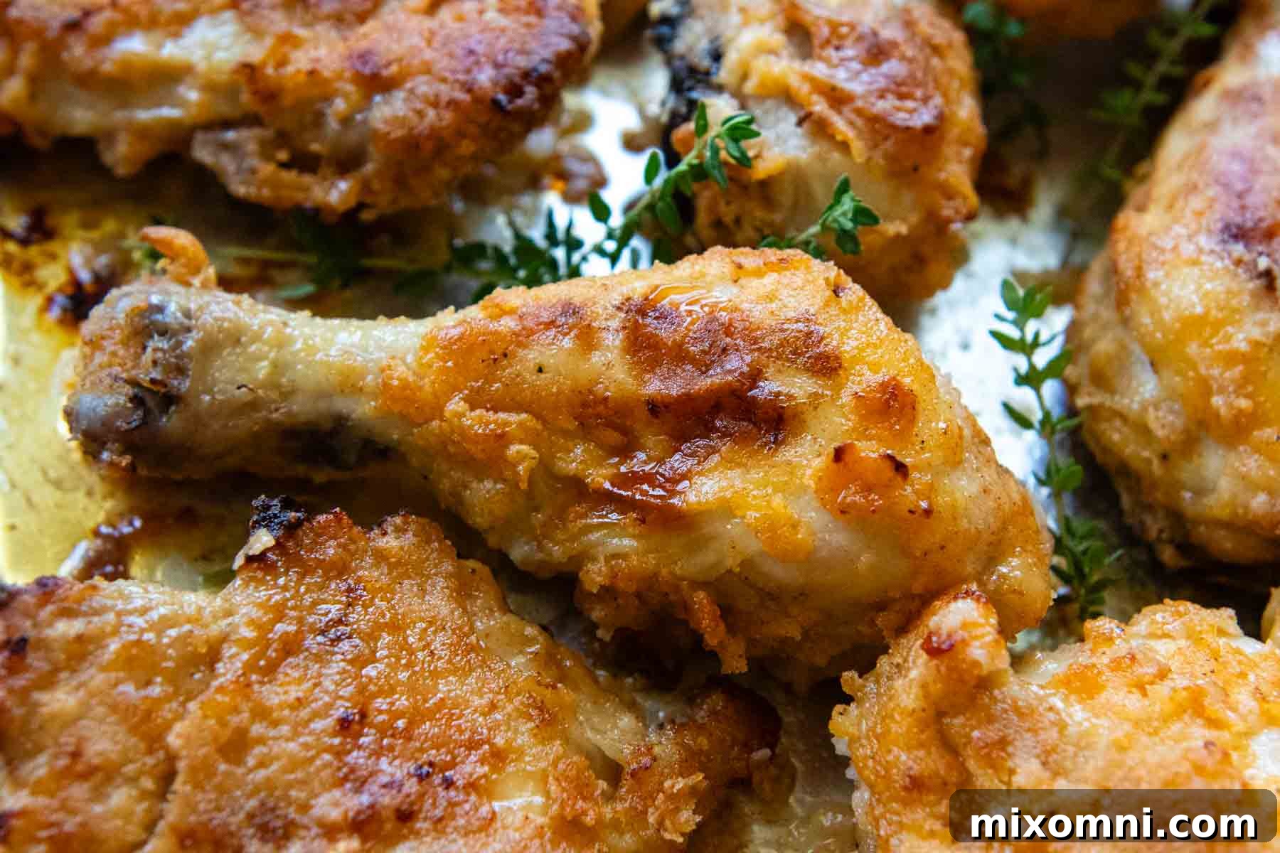 chicken drumstick on a baking sheet surrounded by chicken.