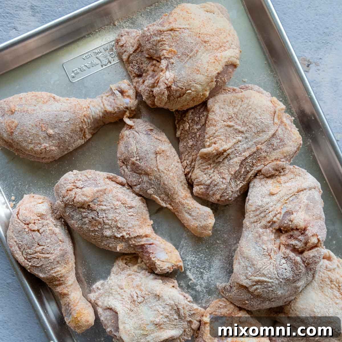 unbaked chicken on a baking sheet.