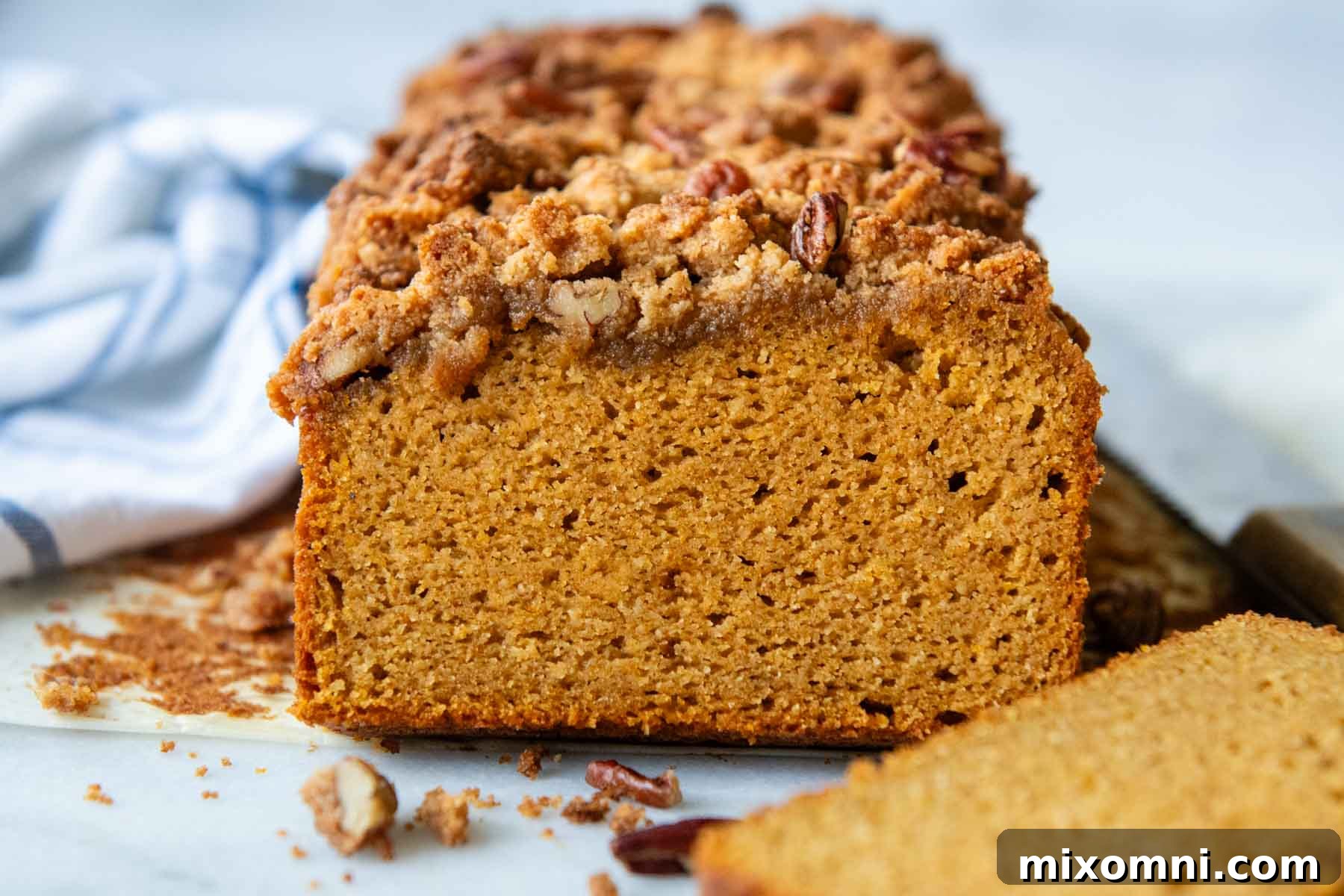 A slice of almond flour pumpkin bread, showing the interior texture of the loaf.