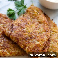 A slice of potato rösti, folded and plated alongside a garnish of fresh parsley, showcasing its inviting texture.