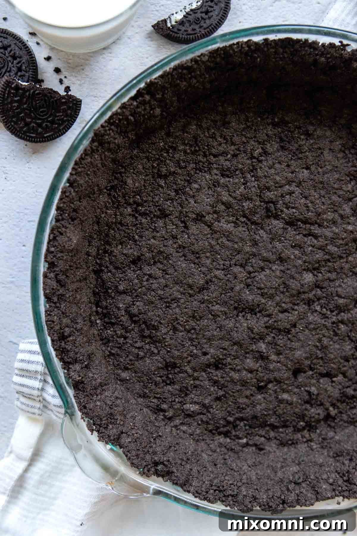 A perfectly baked gluten-free Oreo crust nestled in a clear glass pie dish, ready for your favorite filling.