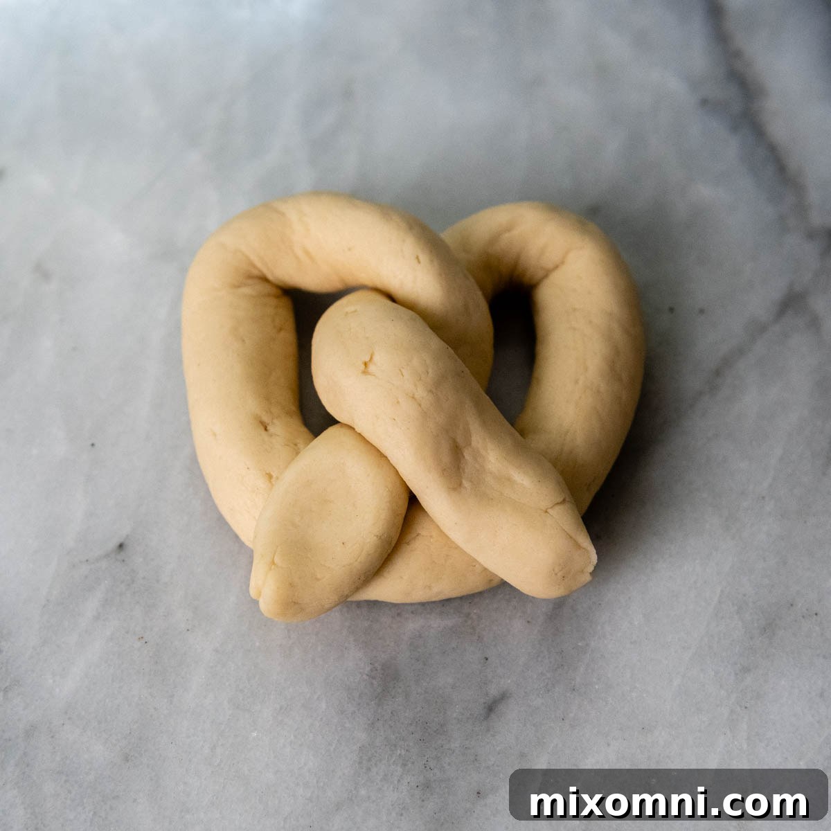 unbaked gluten-free pretzel dough that has been completed twisted into the shape of a pretzel.