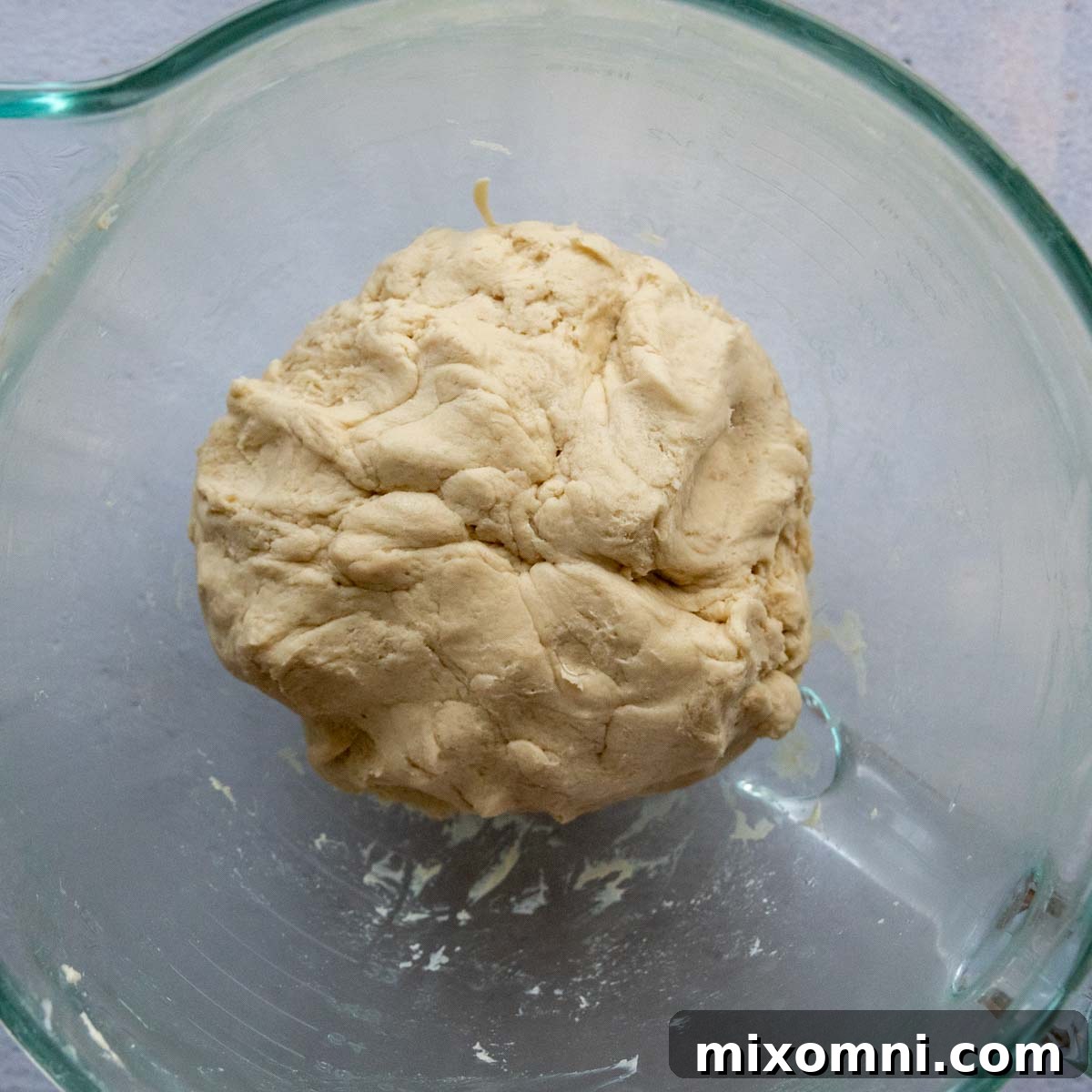 pretzel dough in a glass bowl before rising.