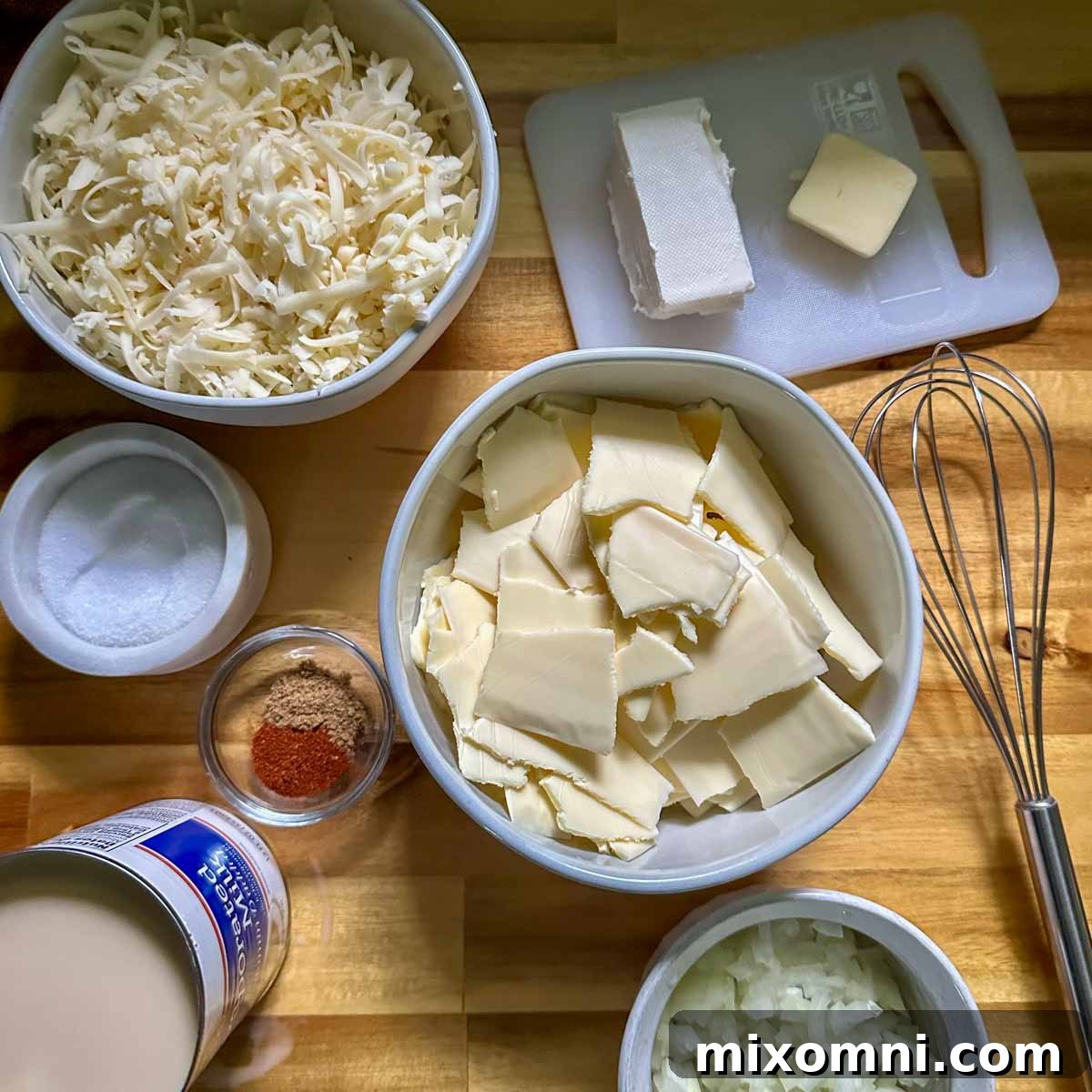 Ingredients for gluten-free queso laid out in small bowls, including grated cheese, diced onions, and spices.