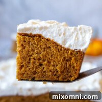 Slice of Gluten-Free Pumpkin Cake topped with fluffy whipped topping.